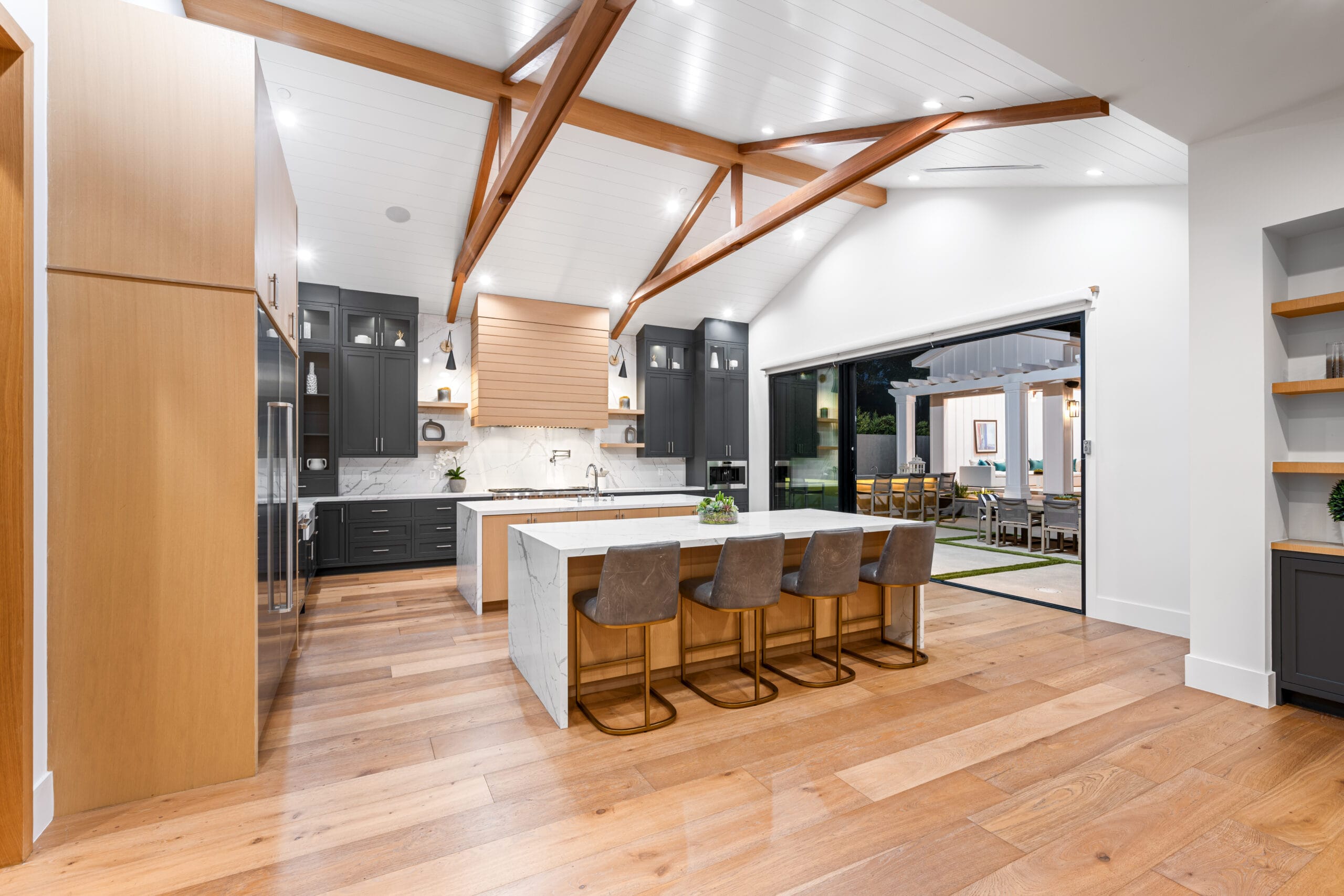 Modern kitchen featuring wooden beams above the island countertop, highlighting home renovations Tampa FL.